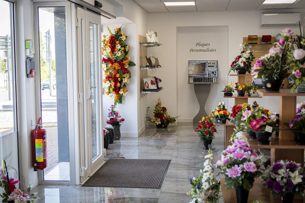 Intérieur d'un magasin de pompes funèbres avec fleurs et articles funéraires.