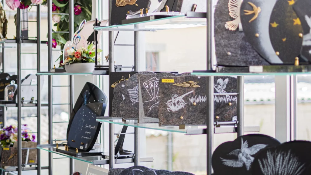 Plaques funéraires personnalisées gravées et urnes exposées en magasin.