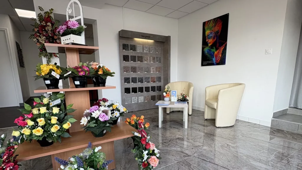 Salon d'accueil d'une agence funéraire avec fauteuils et présentoir.