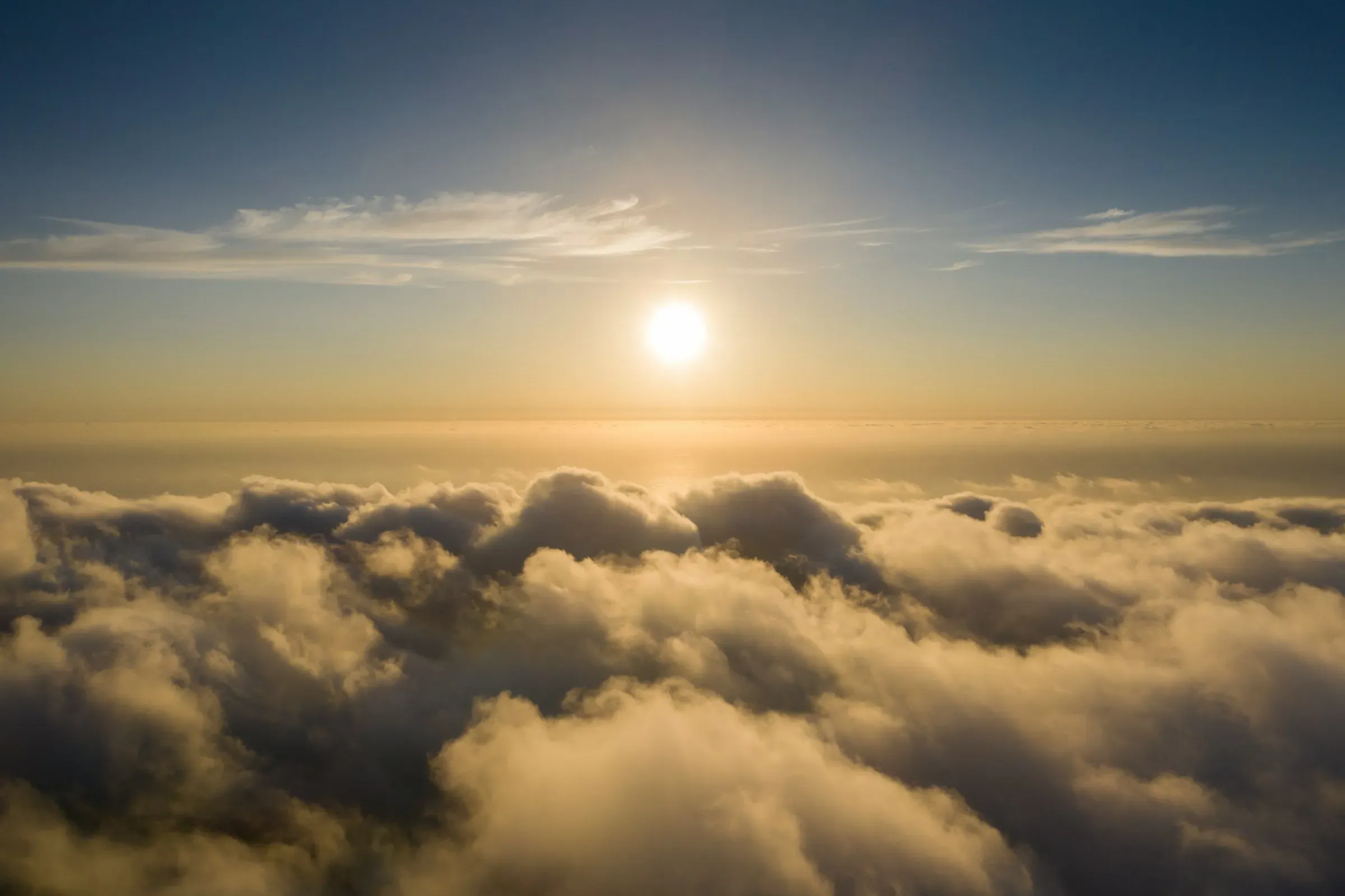 Vue aérienne au-dessus d'une mer de nuages avec coucher de soleil rayonnant