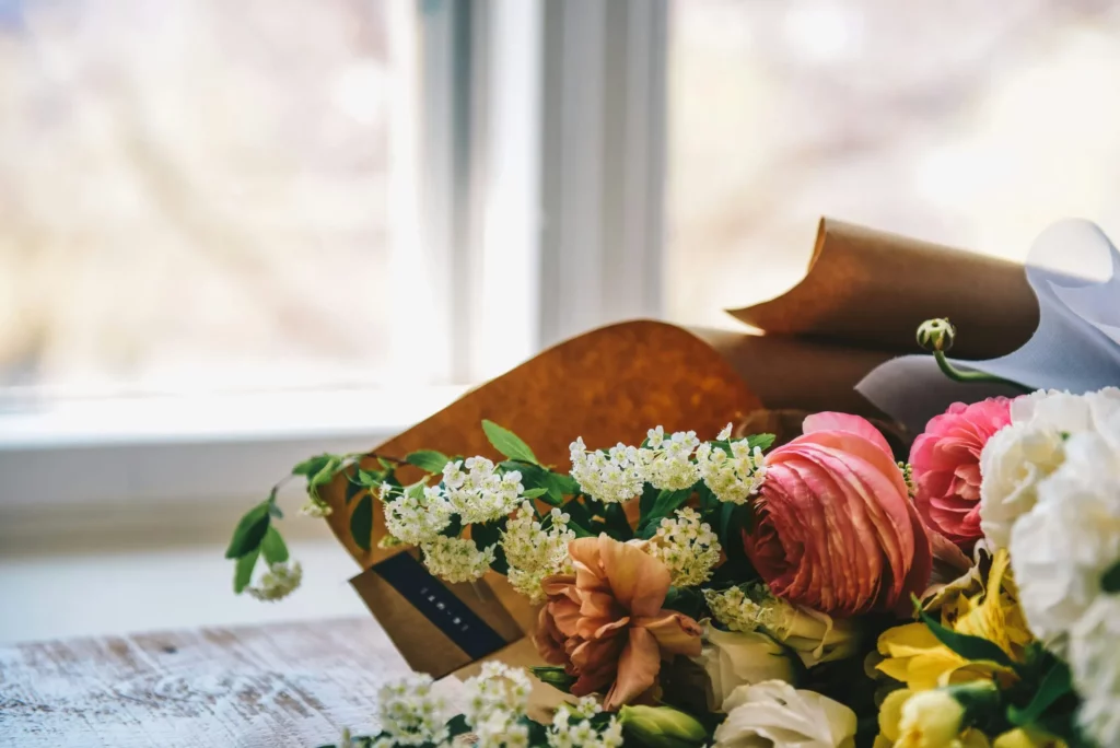 Détail d'un bouquet de fleurs fraîches posé sur une table en bois.